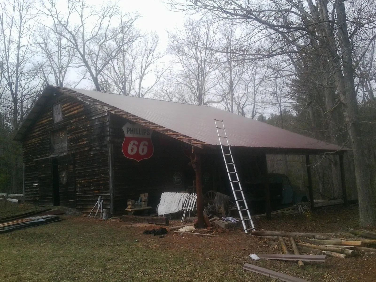 New metal roof on an open sided timber barn with a vintage sign in Islip