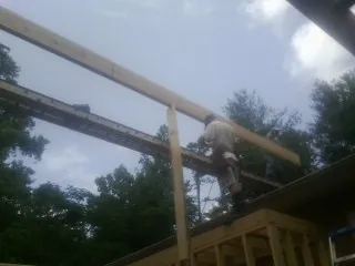 Carpenter setting a ridge beam over a new addition frame — Ice Dam Removal by Roofing Brothers in Islip