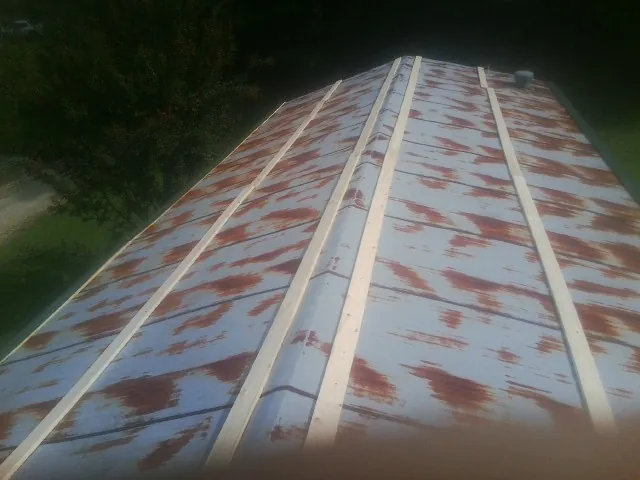 Rusted metal roof panels with new wood purlins before replacement — Storm Damage Roof Repair in Islip by Roofing Brothers