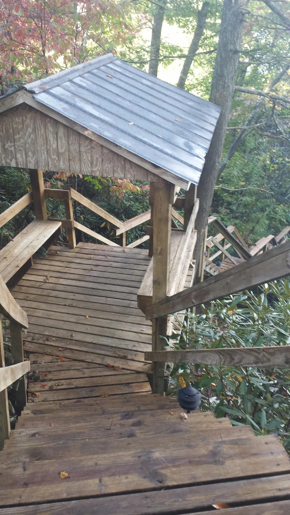 Metal roofed shelter over wooden steps on a wooded walkway — Skylight Repair & Installation work by our crew in Islip