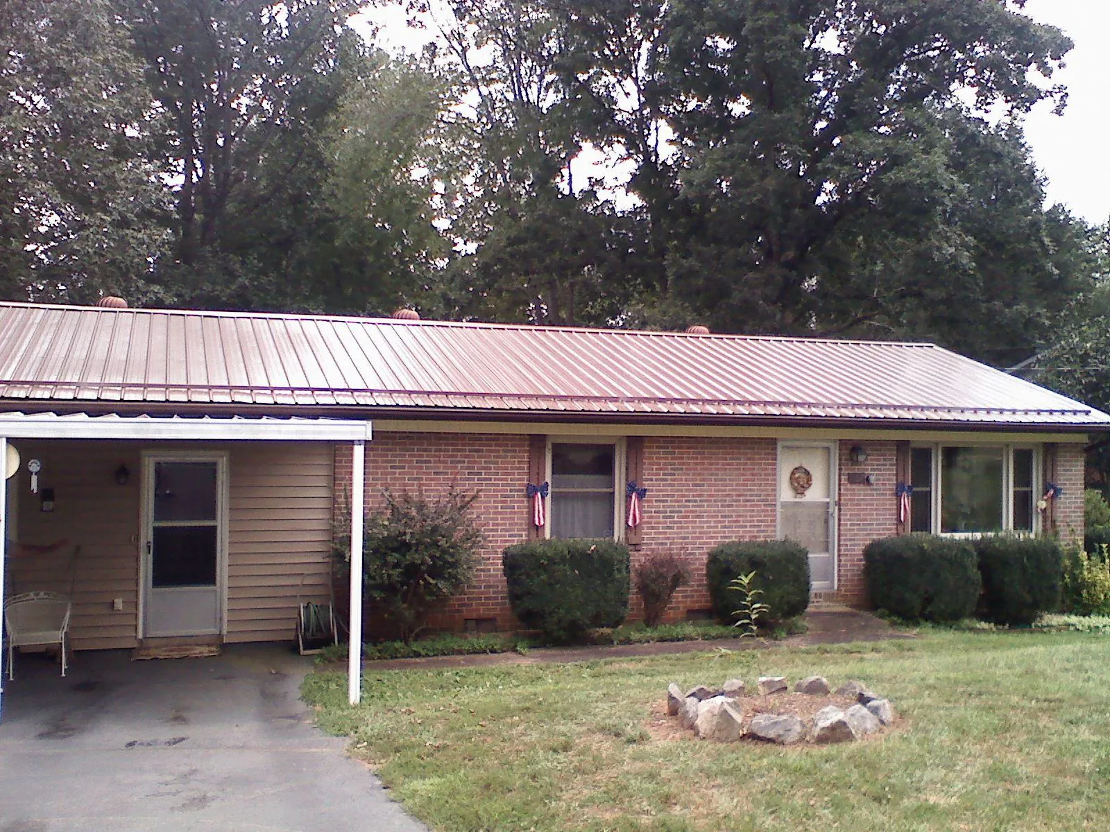 Bronze metal roof and carport on a brick ranch home — Roof Repair work by our crew in Islip